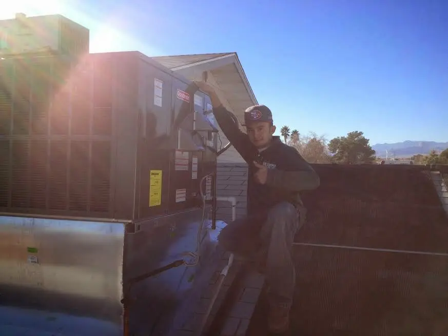 HVAC technician performing HVAC Inspection on a rooftop unit in Broken Arrow